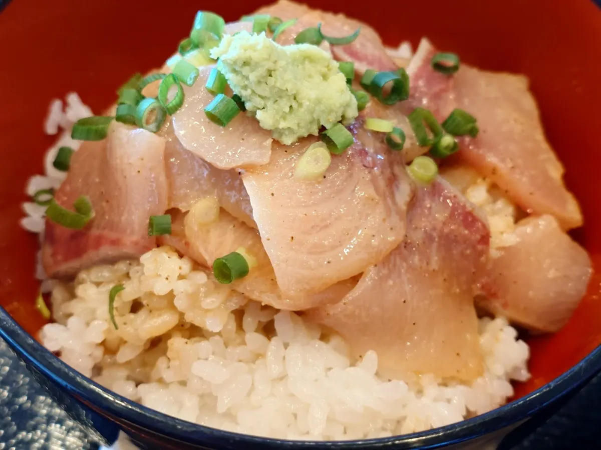 ごまだれをまとった切り身がごはんにのった丼